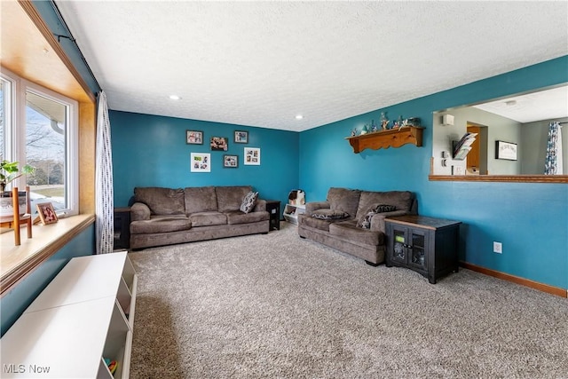 carpeted living area with a textured ceiling and baseboards