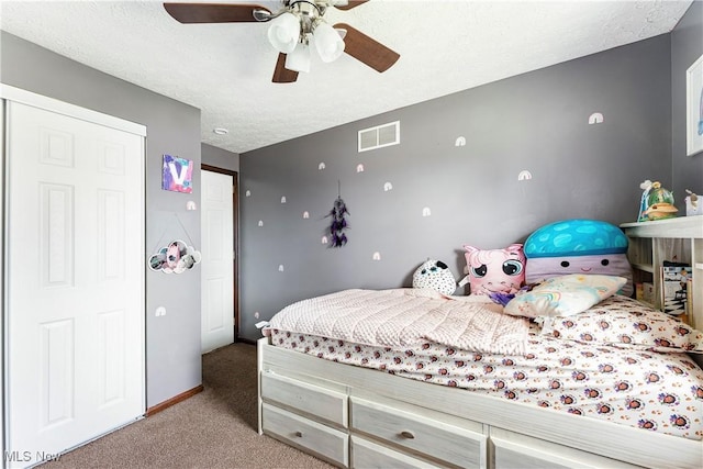 carpeted bedroom featuring baseboards, visible vents, ceiling fan, and a textured ceiling