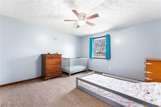 bedroom with carpet floors, a textured ceiling, baseboards, and a ceiling fan