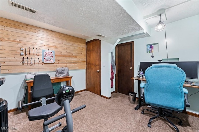 carpeted office space featuring visible vents, a textured ceiling, and baseboards