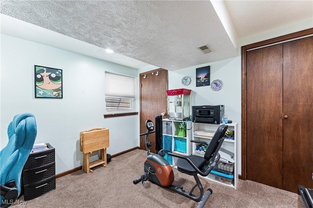 exercise area with a textured ceiling, carpet flooring, visible vents, and baseboards