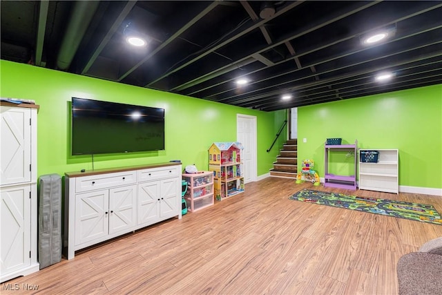 recreation room featuring baseboards and light wood-style floors