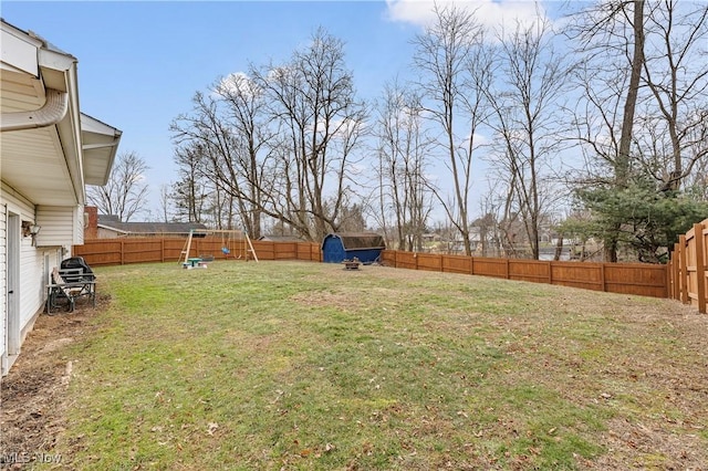 view of yard with a fenced backyard and an outbuilding