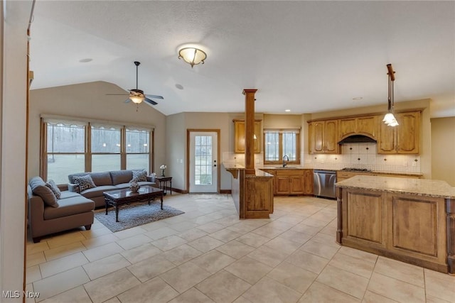 kitchen with light stone counters, a peninsula, open floor plan, appliances with stainless steel finishes, and decorative backsplash