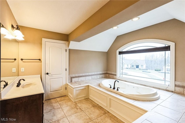 full bathroom with lofted ceiling, a garden tub, vanity, and tile patterned floors