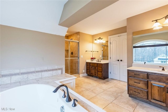 bathroom featuring two vanities, a sink, a shower stall, and a bath