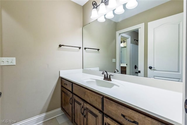 bathroom with tile patterned floors, baseboards, and vanity