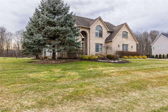 traditional home featuring brick siding and a front lawn