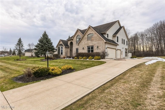 view of front of home with a garage, concrete driveway, a front lawn, and brick siding