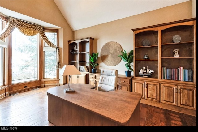 office with lofted ceiling and dark wood finished floors