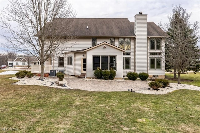 back of property featuring entry steps, a yard, central AC unit, and a chimney