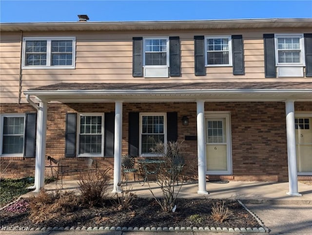 view of front of home with a porch and brick siding