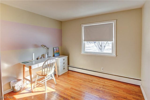 office area featuring a baseboard heating unit, light wood-type flooring, and baseboards