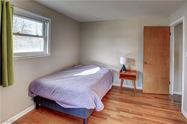 bedroom featuring baseboards and wood finished floors