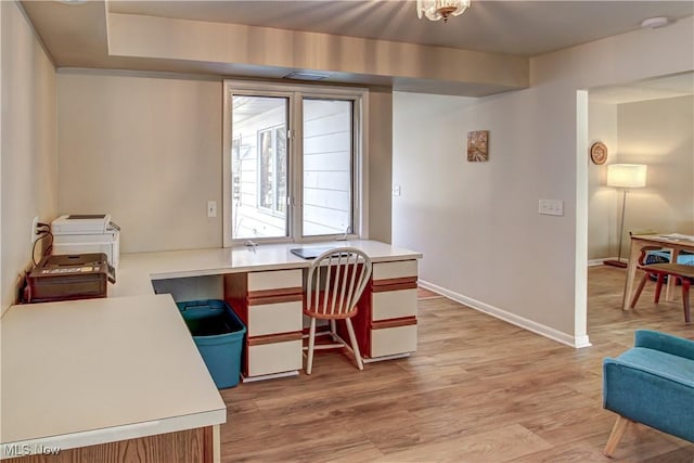 office space with baseboards and light wood-style floors