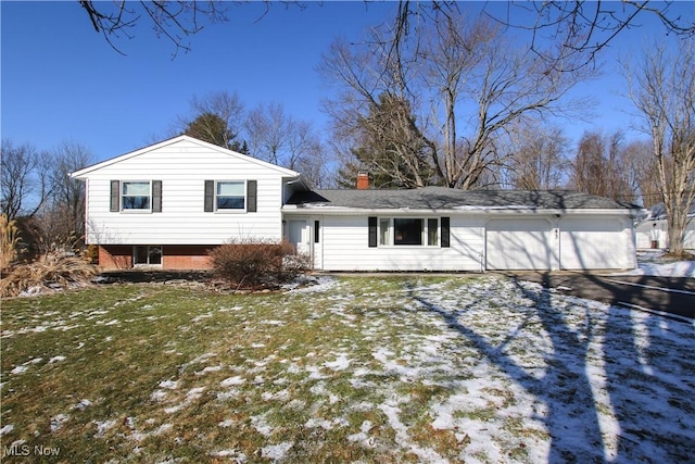 view of front of house with a garage, driveway, a chimney, a front yard, and brick siding