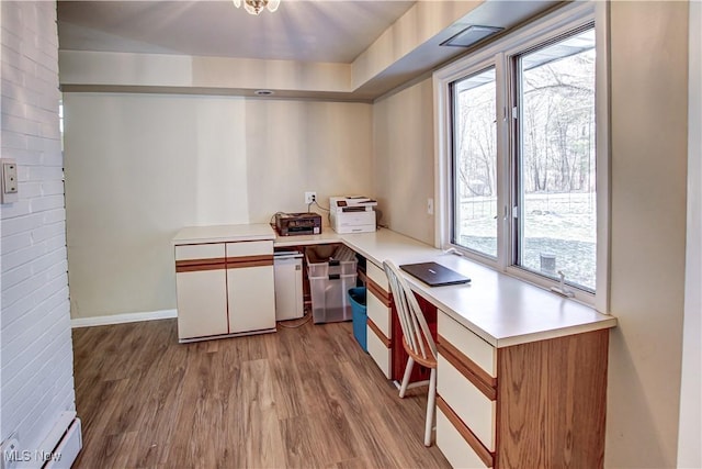 kitchen featuring plenty of natural light, white cabinetry, light countertops, and wood finished floors