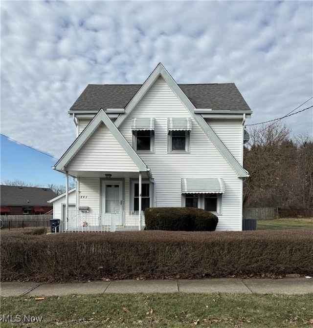 view of front of house with a shingled roof and fence