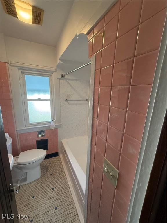 bathroom with shower / washtub combination, tile walls, visible vents, toilet, and tile patterned floors