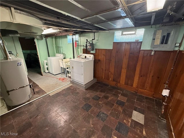 basement featuring a wealth of natural light, washing machine and dryer, wainscoting, and wood walls