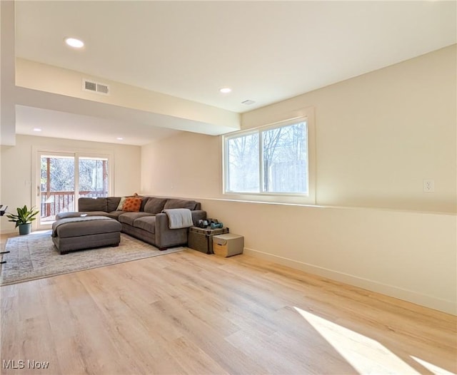 living area with recessed lighting, visible vents, baseboards, and wood finished floors