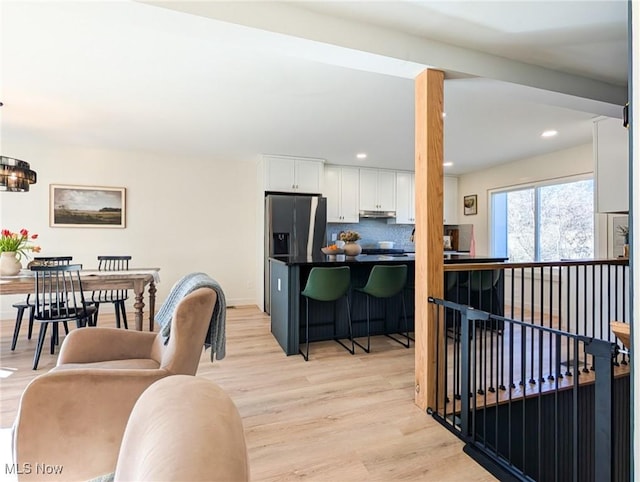 living room featuring a notable chandelier, light wood-style floors, and recessed lighting