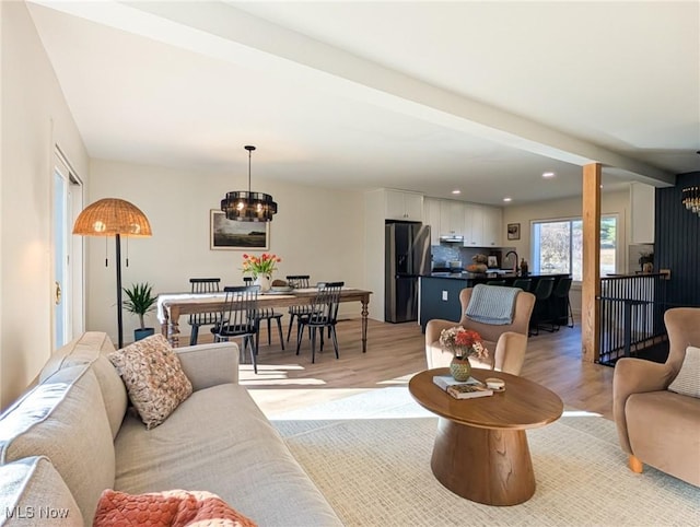 living area featuring recessed lighting, light wood-style floors, and a chandelier