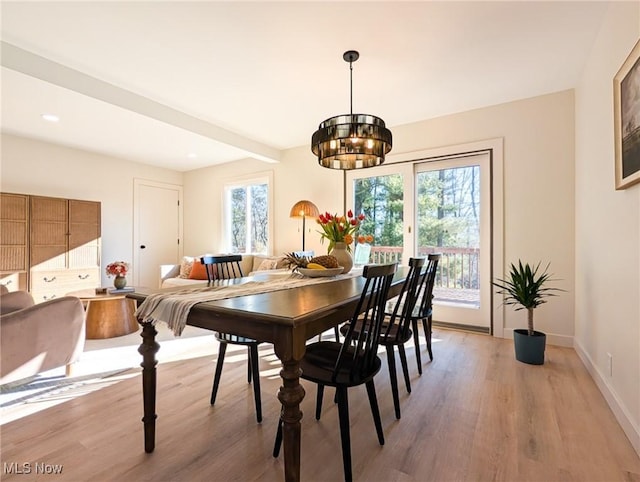 dining space with light wood-type flooring, plenty of natural light, and baseboards