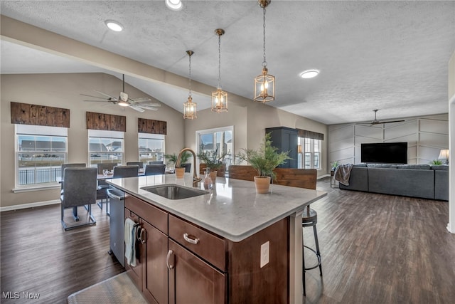 kitchen with a textured ceiling, a sink, a ceiling fan, open floor plan, and dark wood-style floors