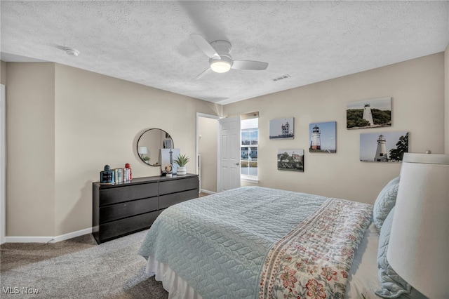 bedroom with carpet floors, baseboards, visible vents, and a textured ceiling