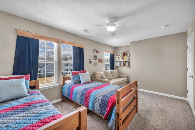 carpeted bedroom featuring visible vents, baseboards, ceiling fan, and a textured ceiling