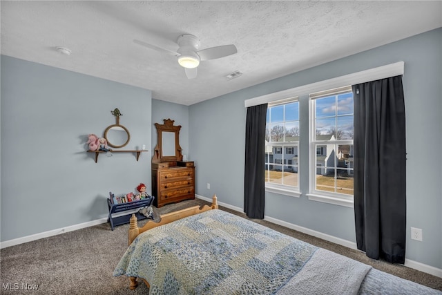 bedroom featuring a textured ceiling, ceiling fan, visible vents, baseboards, and carpet