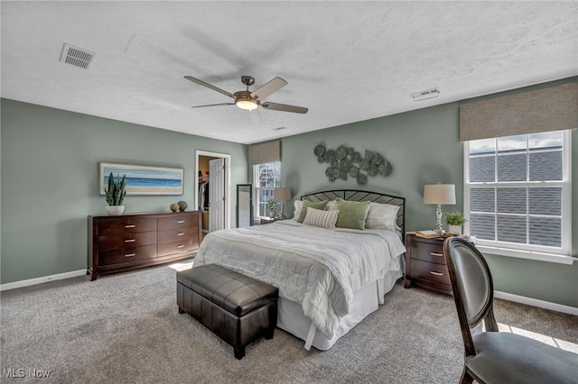 bedroom with carpet floors, baseboards, visible vents, and a textured ceiling