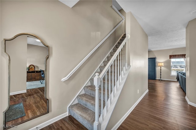 stairway with baseboards and wood finished floors