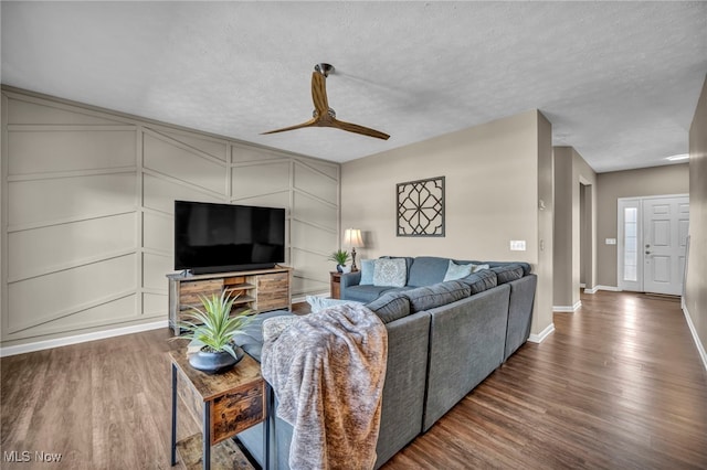 living area with a textured ceiling, a ceiling fan, and wood finished floors