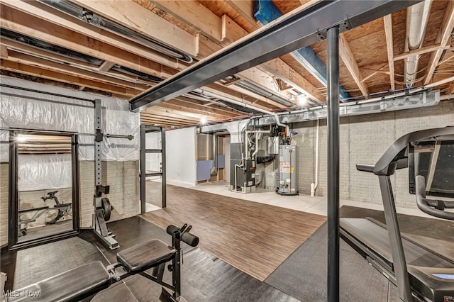 workout area with gas water heater, brick wall, and heating unit