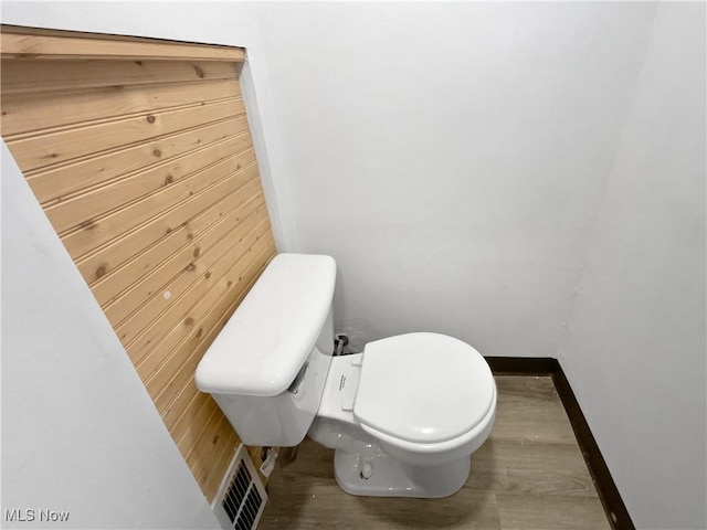 bathroom featuring baseboards, visible vents, toilet, and wood finished floors