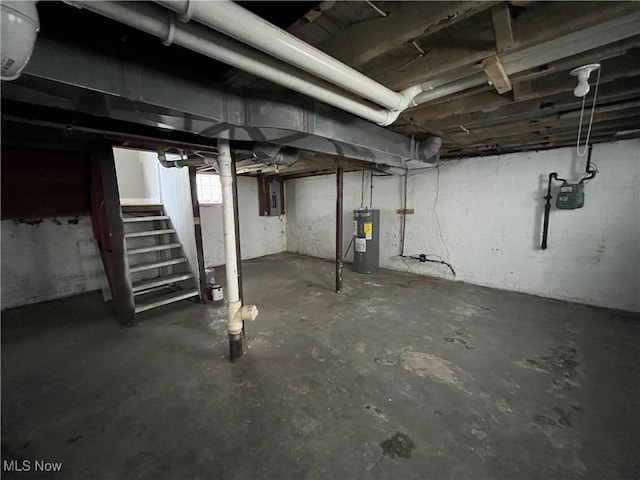 basement with water heater, stairway, and electric panel