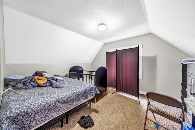 carpeted bedroom with lofted ceiling, a textured ceiling, and baseboards