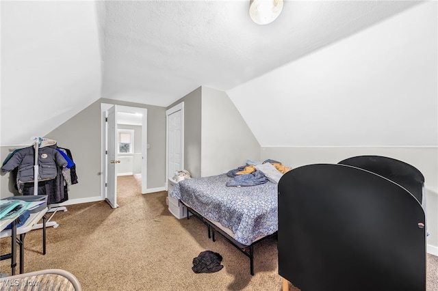 bedroom featuring carpet floors, vaulted ceiling, a textured ceiling, and baseboards