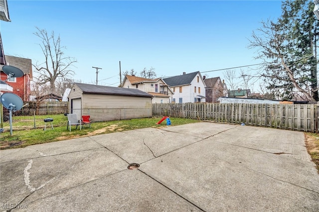 view of patio with an outbuilding, a fenced backyard, and a residential view