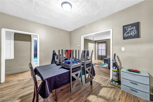 dining room with a textured ceiling and wood finished floors