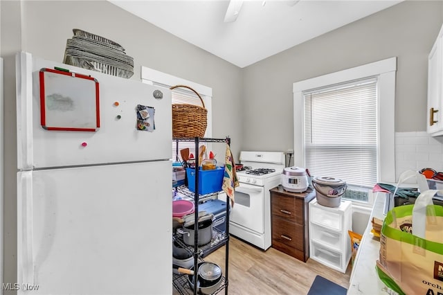 kitchen featuring white appliances, white cabinetry, and light wood-style floors