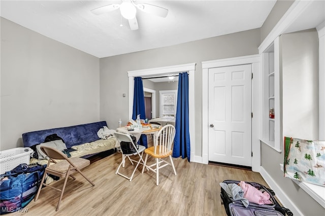 interior space with ceiling fan, wood finished floors, and baseboards