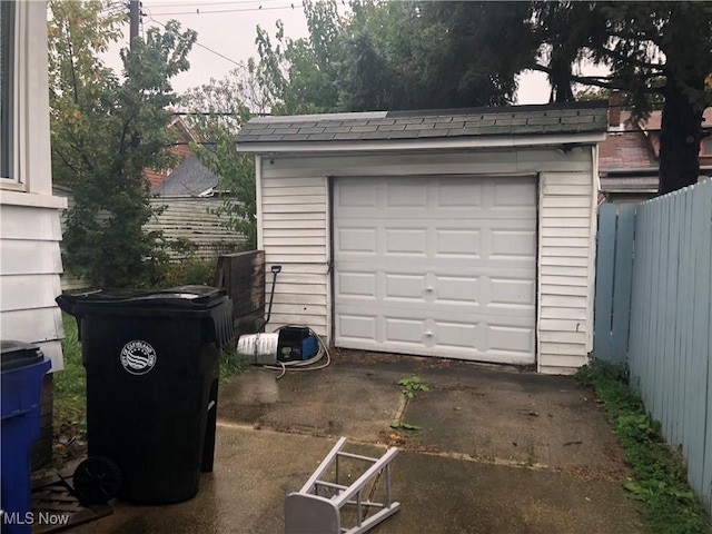 detached garage with driveway and fence