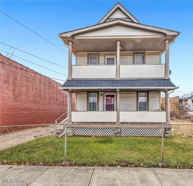 view of front of property featuring a porch, a front yard, a shingled roof, and a balcony