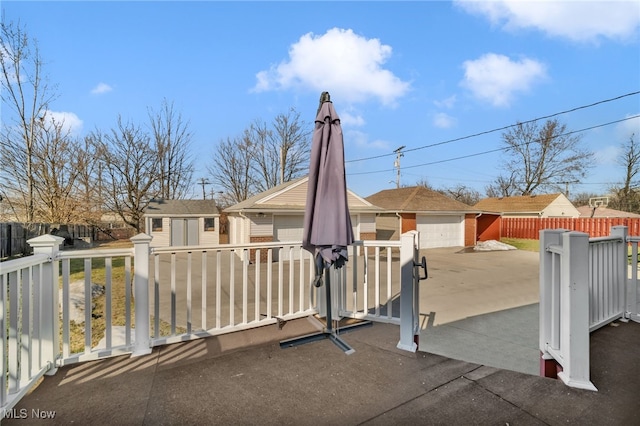 view of patio featuring an outbuilding, a detached garage, and fence