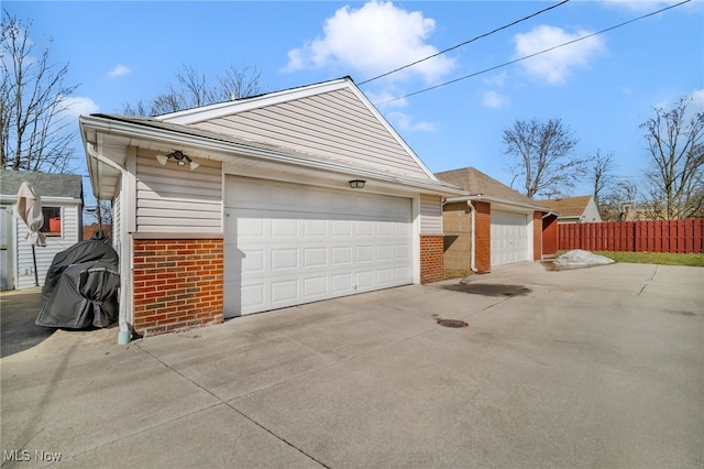 garage with driveway and fence