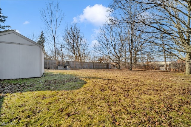 view of yard with an outbuilding, a shed, and fence