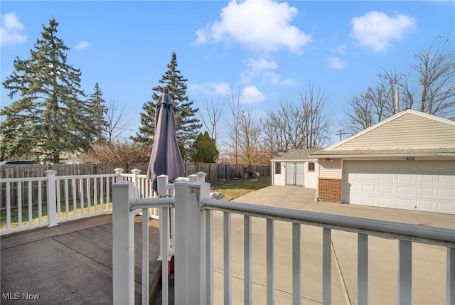 exterior space with a garage, fence private yard, an outdoor structure, and brick siding